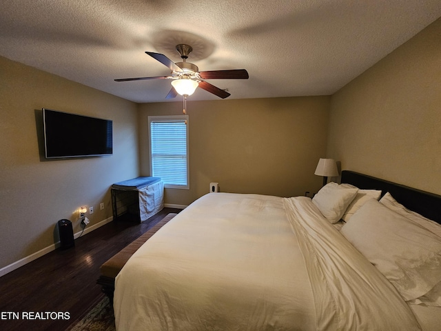 bedroom with wood finished floors, a textured ceiling, baseboards, and ceiling fan