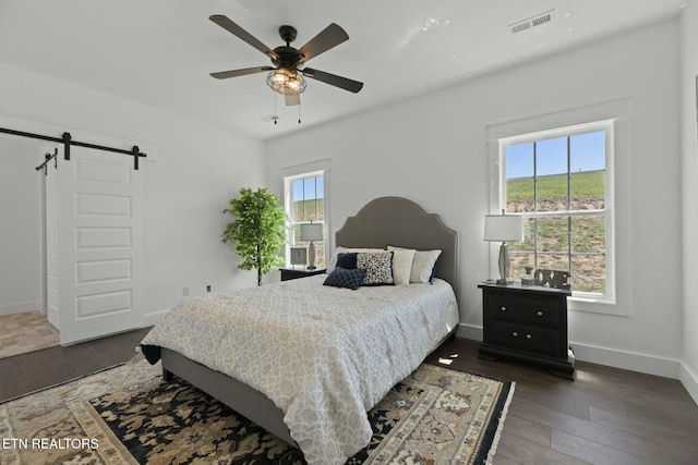 252 Old Middlesboro Hwy, Lafollette, TN 37766 - bedroom featuring a barn door, baseboards, wood finished floors, and visible vents