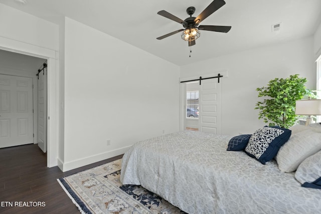 252 Old Middlesboro Hwy, Lafollette, TN 37766 - bedroom featuring a barn door, visible vents, dark wood-type flooring, baseboards, and multiple windows