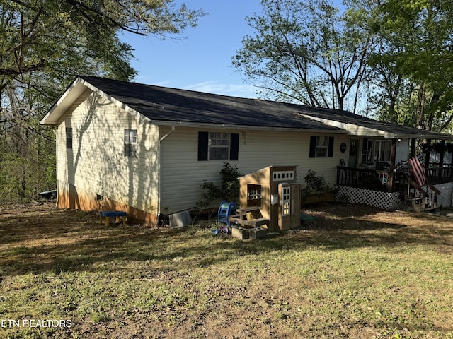 back of house with a wooden deck and a lawn
