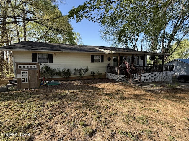 back of house featuring a deck and a lawn