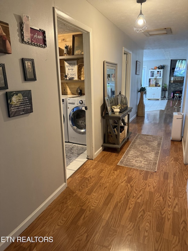 corridor with baseboards, attic access, and wood finished floors