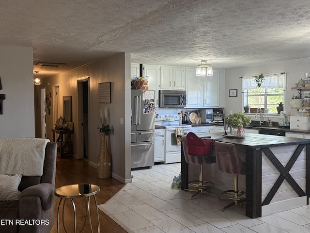 kitchen with visible vents, white cabinets, appliances with stainless steel finishes, and marble finish floor