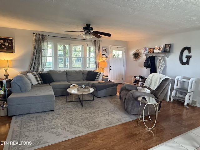 living room with a wealth of natural light, a textured ceiling, and ceiling fan
