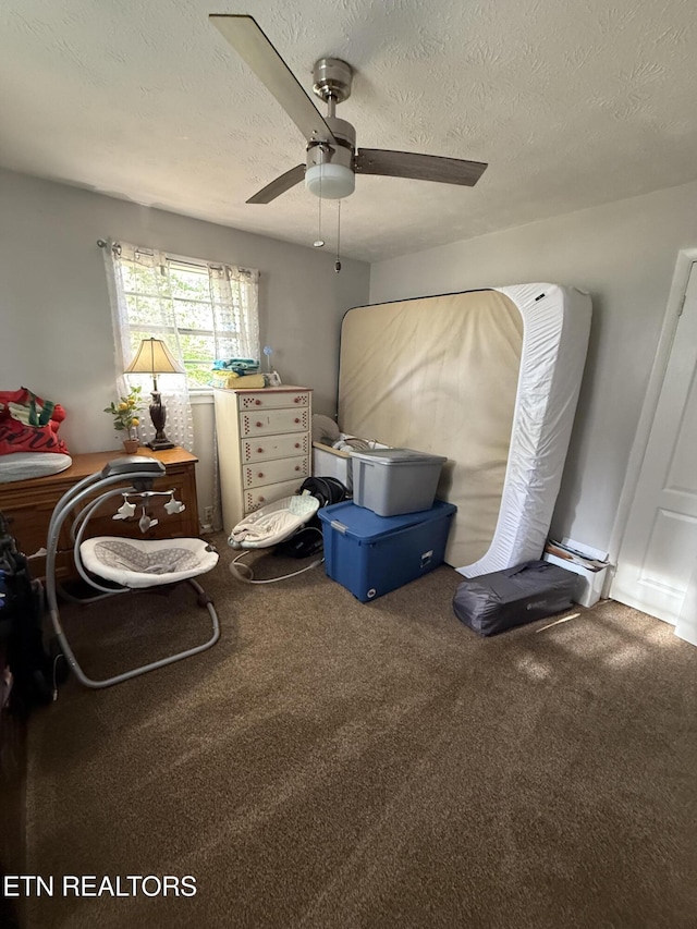 carpeted bedroom featuring ceiling fan and a textured ceiling