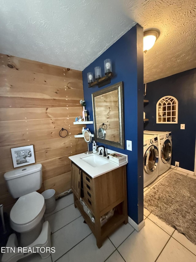 bathroom with tile patterned flooring, washing machine and dryer, a textured ceiling, and toilet