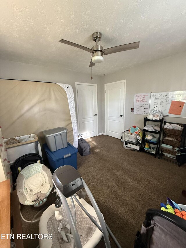 interior space with carpet, a textured ceiling, and ceiling fan