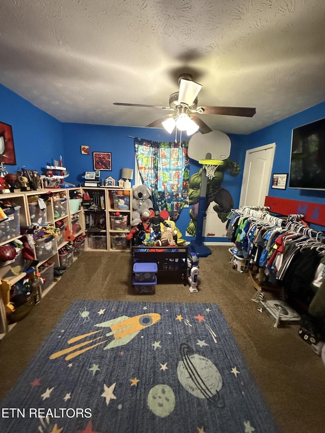 game room featuring ceiling fan, carpet flooring, and a textured ceiling