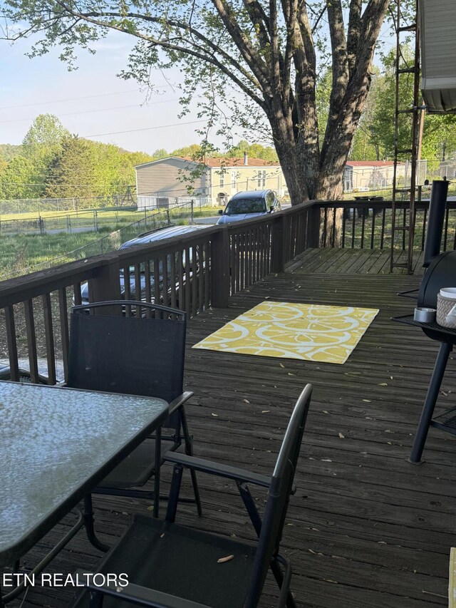 wooden terrace featuring fence