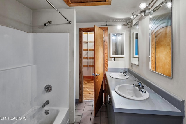 bathroom featuring tub / shower combination, double vanity, tile patterned floors, and a sink