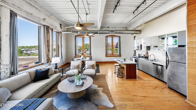 kitchen featuring a breakfast bar, track lighting, appliances with stainless steel finishes, and open floor plan