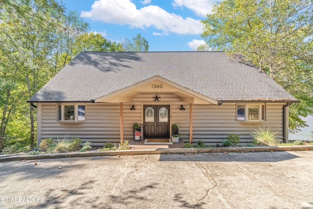 chalet / cabin with faux log siding and roof with shingles