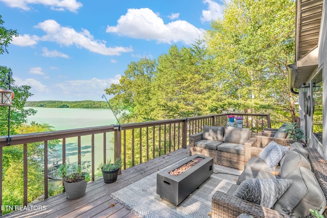 wooden deck featuring an outdoor living space with a fire pit and a water view