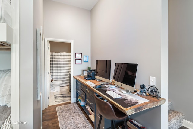 home office featuring baseboards and dark wood-type flooring