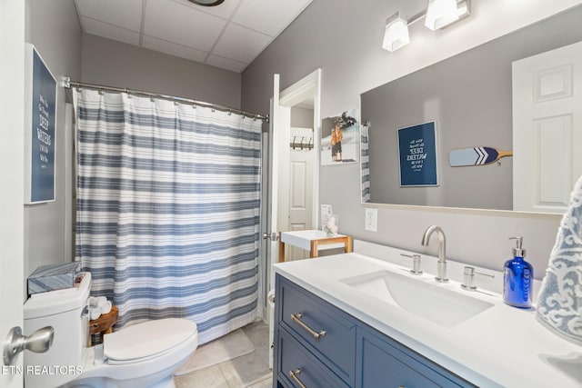 bathroom featuring a paneled ceiling, vanity, curtained shower, and toilet