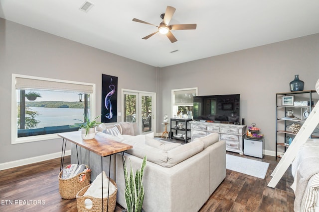 living room with dark wood finished floors, visible vents, baseboards, and ceiling fan