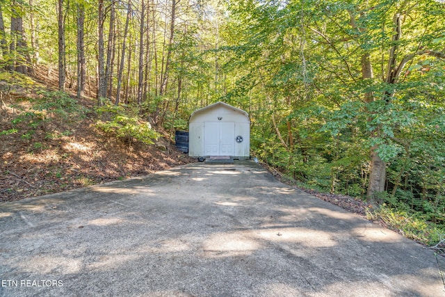garage featuring a storage shed and a wooded view