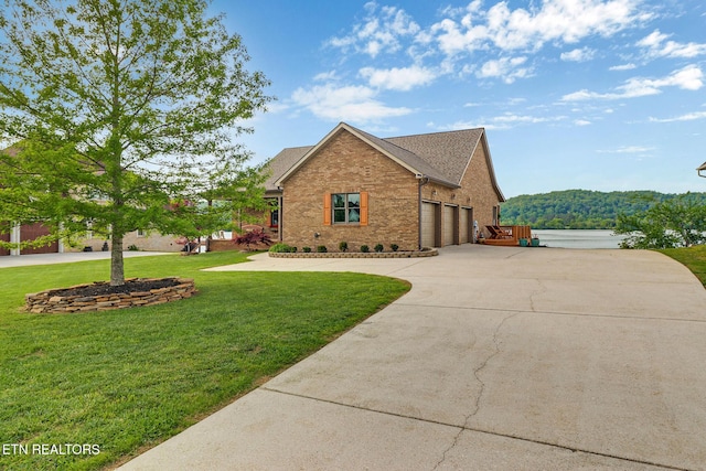 view of front of property featuring an attached garage, a front lawn, brick siding, and concrete driveway