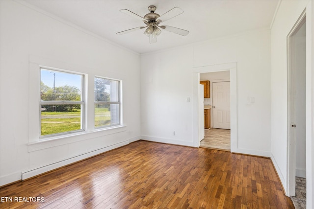 spare room featuring hardwood / wood-style floors, crown molding, baseboard heating, and ceiling fan