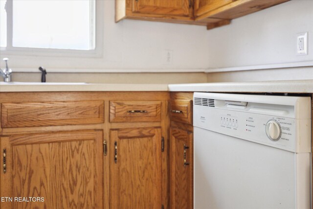 details with white dishwasher, light countertops, brown cabinets, and a sink