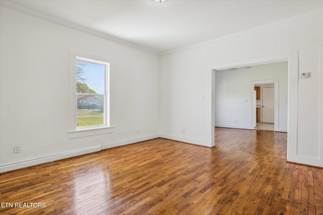 unfurnished room featuring baseboards, ornamental molding, and wood-type flooring