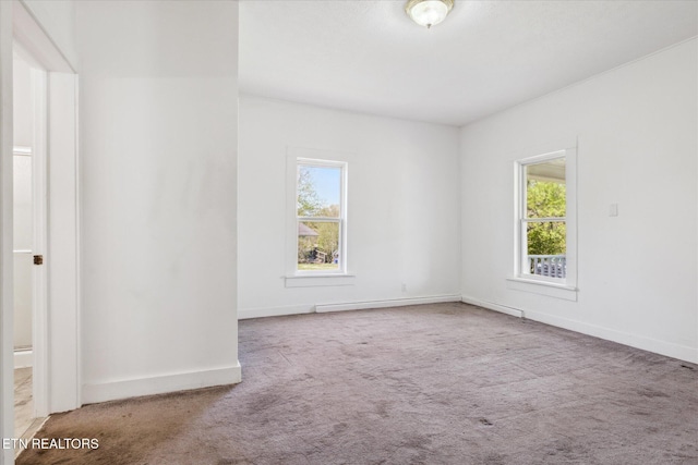 spare room with baseboards and carpet floors