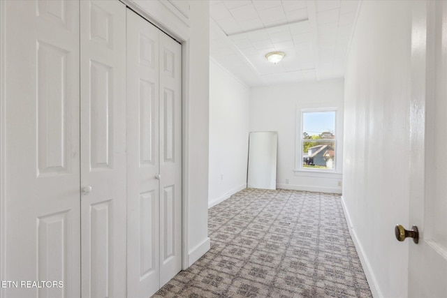 hall with baseboards and carpet