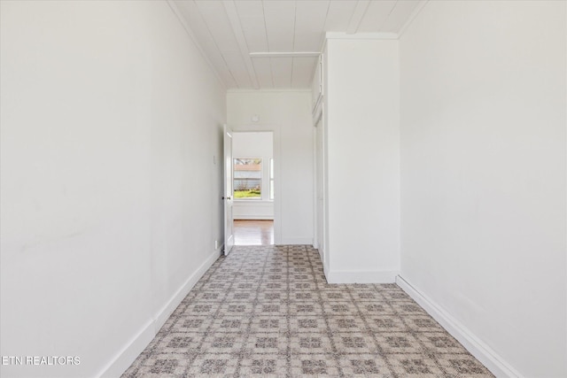 hallway with crown molding and baseboards
