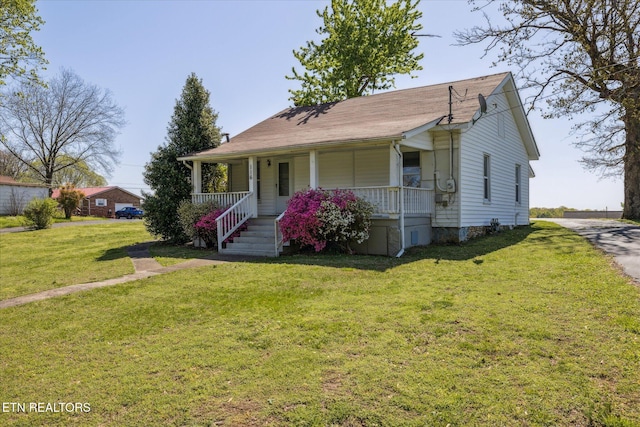 bungalow featuring covered porch and a front yard