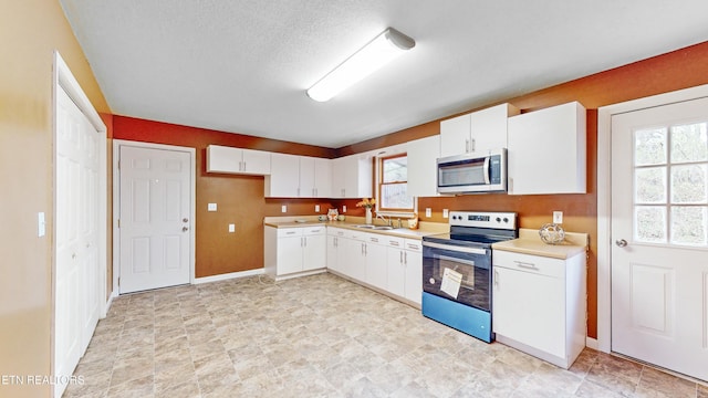 146 Sandy Hill Rd, Lafollette, TN 37766 - kitchen featuring a sink, white cabinetry, stainless steel appliances, and light countertops