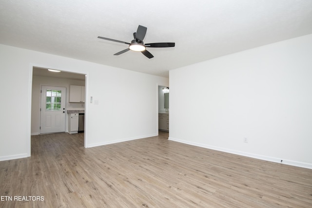 unfurnished living room featuring light wood-type flooring, a ceiling fan, and baseboards