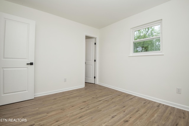unfurnished room featuring baseboards and wood finished floors