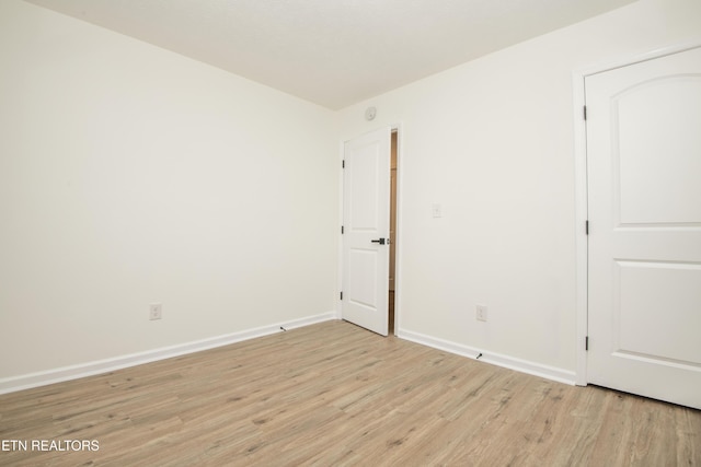 empty room with baseboards and light wood finished floors