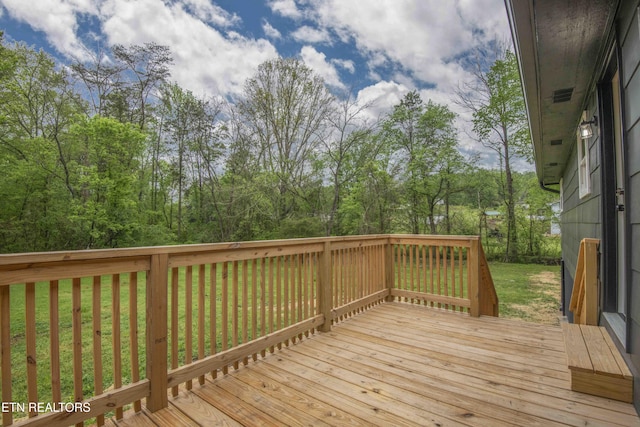 wooden terrace featuring a lawn