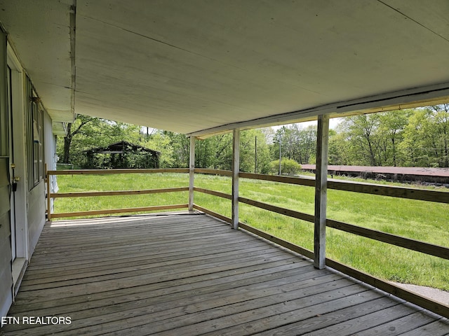 wooden terrace with a lawn