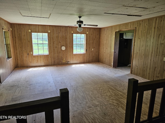 empty room with wood walls and ceiling fan