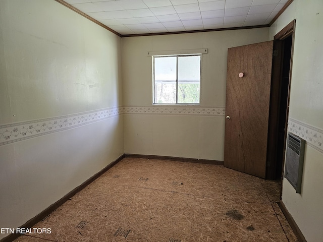 spare room with ornamental molding and heating unit