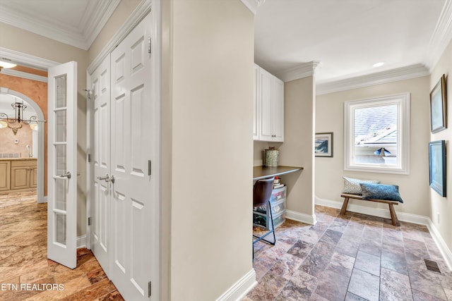 hall with crown molding, stone tile floors, visible vents, and baseboards