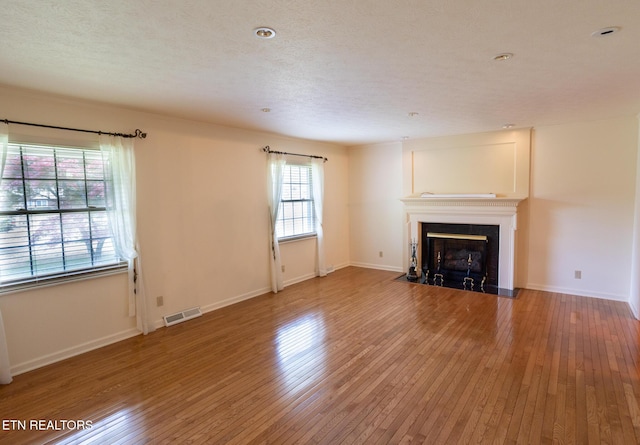 23 Windhaven Ln, Oak Ridge, TN 37830 - unfurnished living room with a fireplace with flush hearth, baseboards, hardwood / wood-style flooring, and visible vents