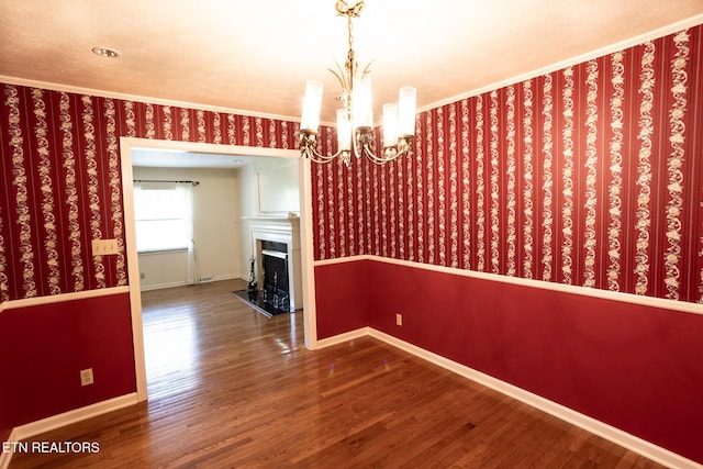 23 Windhaven Ln, Oak Ridge, TN 37830 - unfurnished dining area featuring baseboards, a notable chandelier, wallpapered walls, wood finished floors, and crown molding