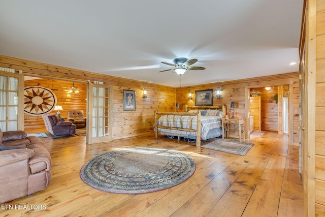 bedroom featuring wood walls, hardwood / wood-style flooring, and french doors