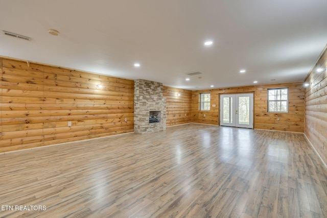 unfurnished living room featuring recessed lighting, wood finished floors, visible vents, and a stone fireplace