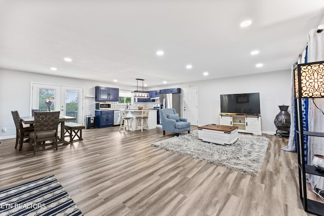 living room with recessed lighting, light wood-type flooring, and baseboards