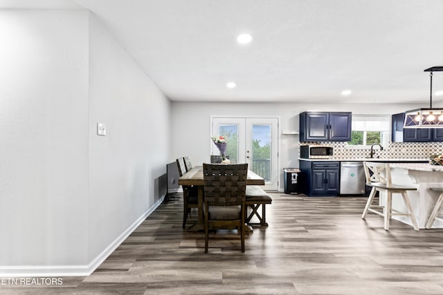 dining room with baseboards, french doors, wood finished floors, and recessed lighting