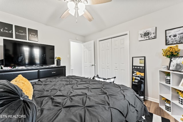 bedroom featuring ceiling fan, baseboards, wood finished floors, and a closet