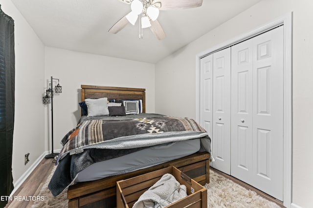 bedroom featuring baseboards, a ceiling fan, wood finished floors, and a closet