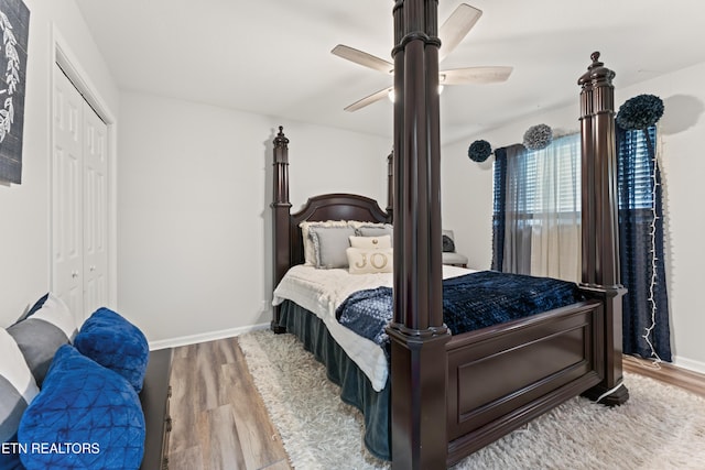 bedroom with wood finished floors, a closet, baseboards, and ceiling fan