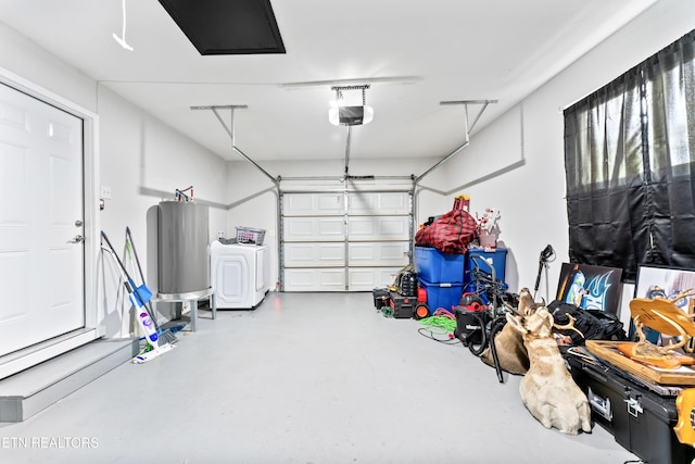 garage featuring water heater, a garage door opener, and washer / clothes dryer
