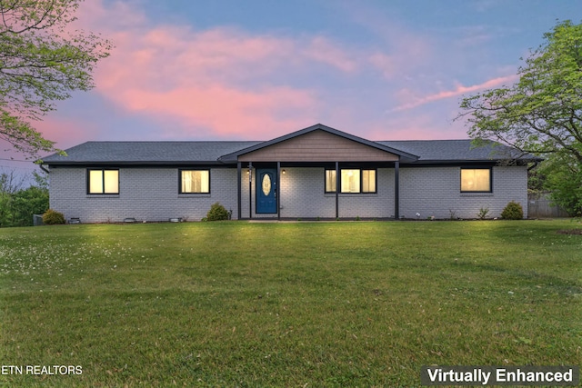 ranch-style home with a lawn and brick siding