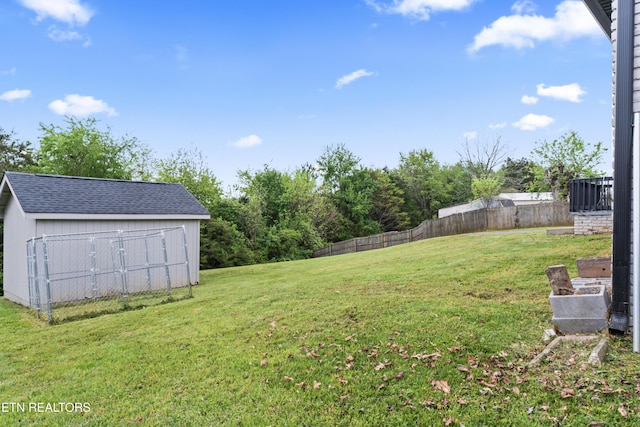 view of yard with an outdoor structure, fence, and a storage unit